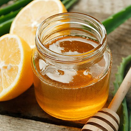 Home spa skincare ingredients. Yellow honey in glass jar and lemon, Aloe Vera, Natural beauty product closeup